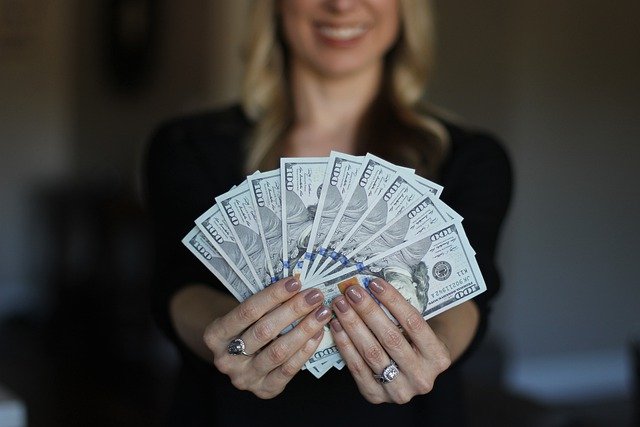Kobieta trzyma w dłoniach wymienione pieniędze przed wyjazdem